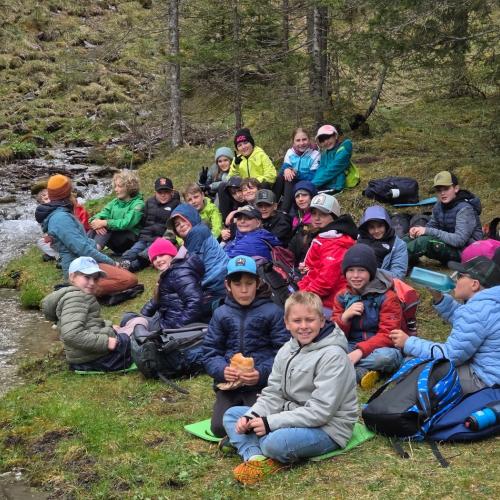 Kinder beim Jausnen am Bach