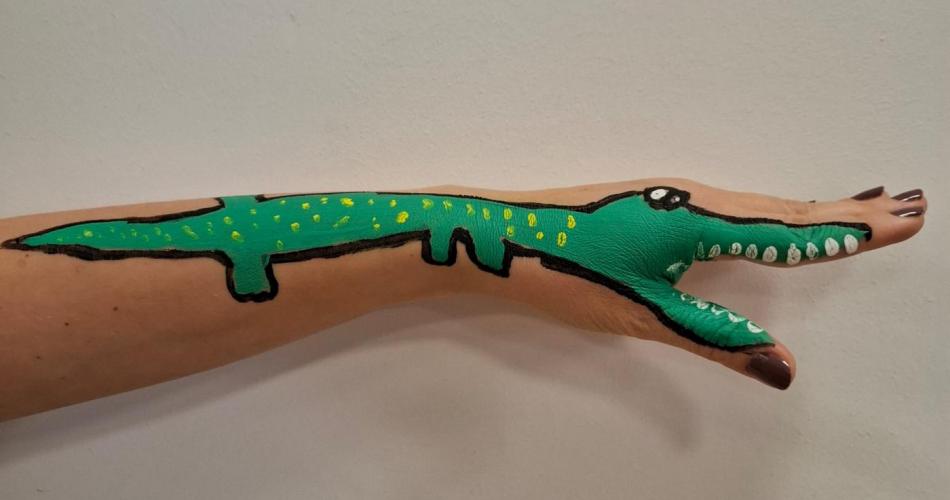 Eine Hand mit einem Krokodilbild